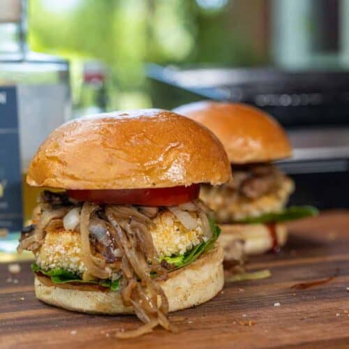 Knuspriger Reggie Burger mit paniertem Grillkäse, frischen Tomaten, Salat und BBQ-Soße auf geröstetem Bun