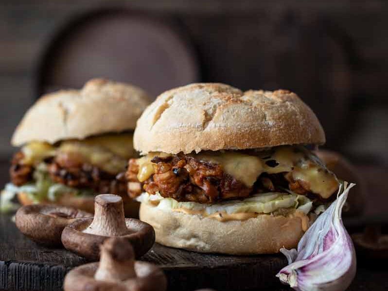 Saftiger vegetarischer Pilzburger mit Shitake-Patties, Salat und Käse im Burger Bun