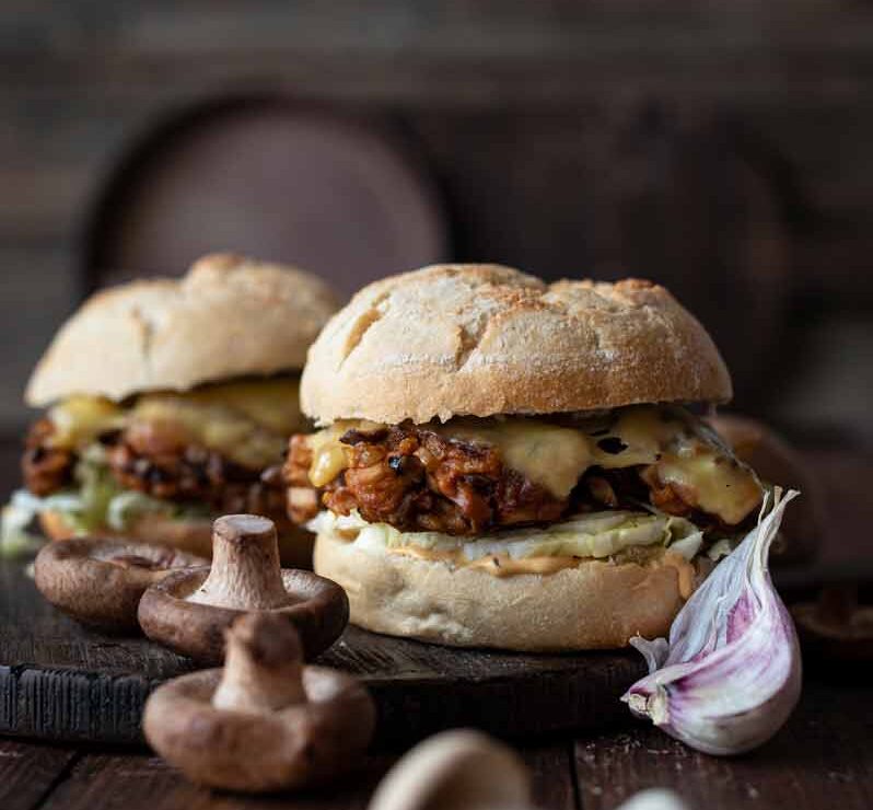 Vegetarischer Pilzburger mit Shitake-Patties Saftiger vegetarischer Pilzburger mit Shitake-Patties, Salat und Käse im Burger Bun