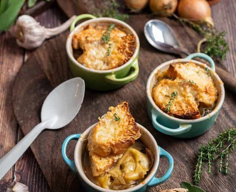 Zwiebelsuppe mit Tortellini, goldbraun gratiniertem Gruyère und Baguette in einer Suppentasse
