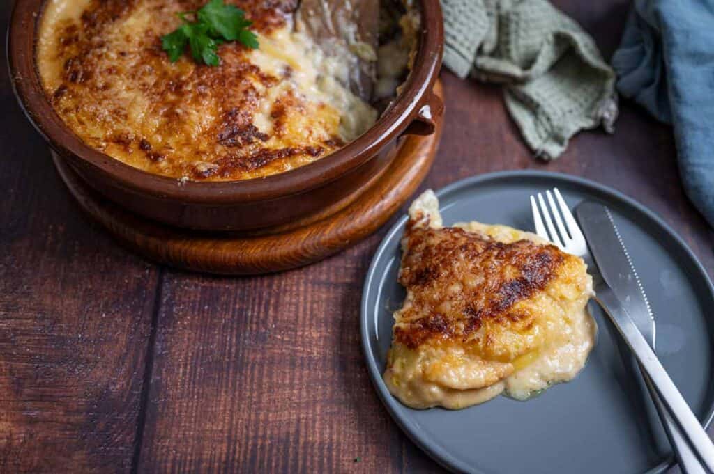 Dünn gehobelte rohe Kartoffeln werden mit Sahne übergossen und für ein vegetarisches Kartoffelgratin geschichtet