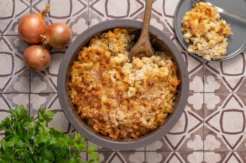 Auflaufform mit Mac and Cheese, knuspriger Käsekruste und karamellisierten Zwiebeln