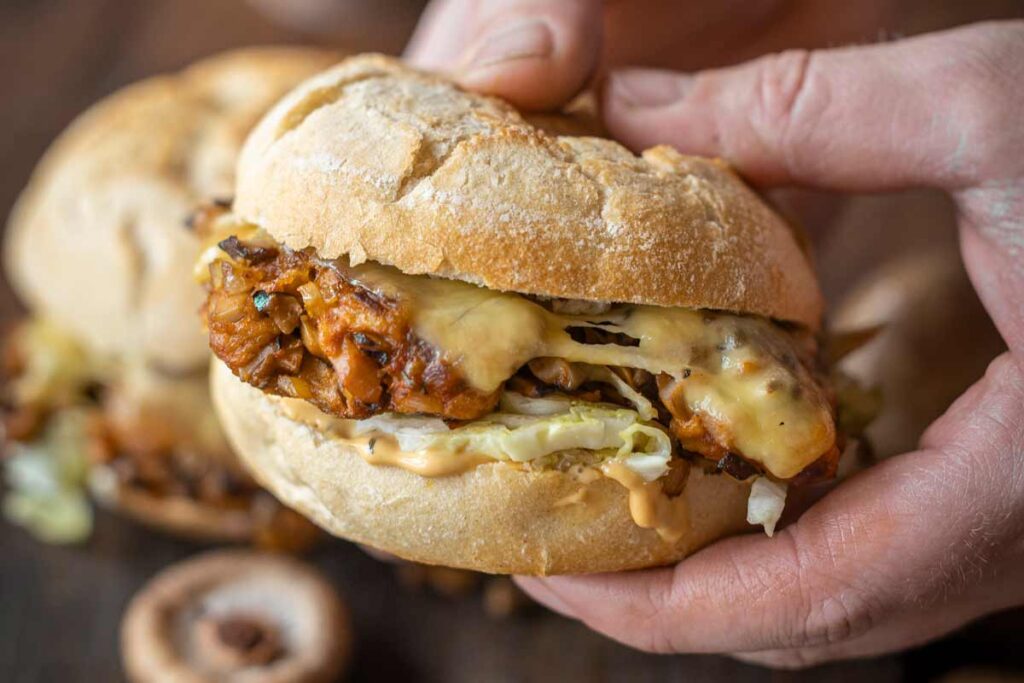 Frischer Veggie Pilzburger mit Shitake-Patties, geschmolzenem Käse, Eisbergsalat und cremiger Burgersoße